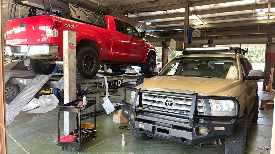 Vehicles on lifts inside the Auto Max service bay